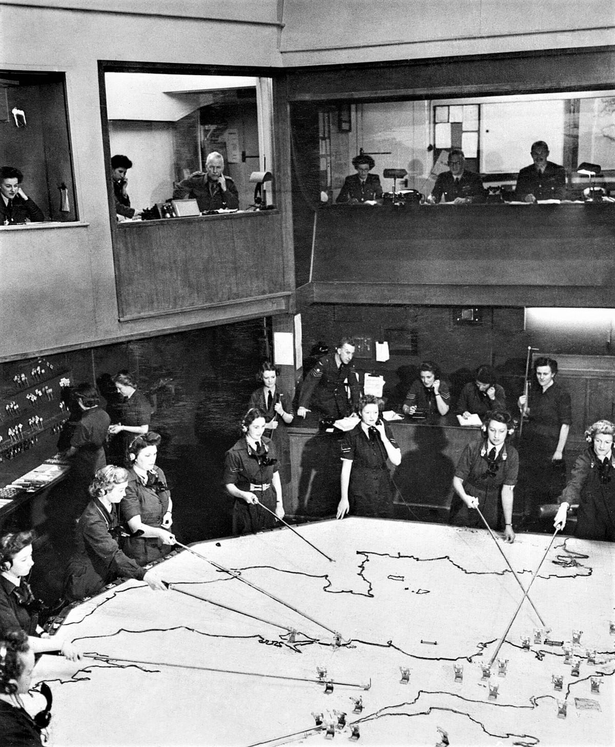 The Operations Room at RAF Fighter Command's No. 10 Group Headquarters, Rudloe Manor (RAF Box), Wiltshire, showing WAAF plotters and duty officers at work, 1943. General view of the Operations Room at No. 10 Group Headquarters, Rudloe Manor (RAF Box), Wiltshire, showing WAAF plotters and duty officers at work.